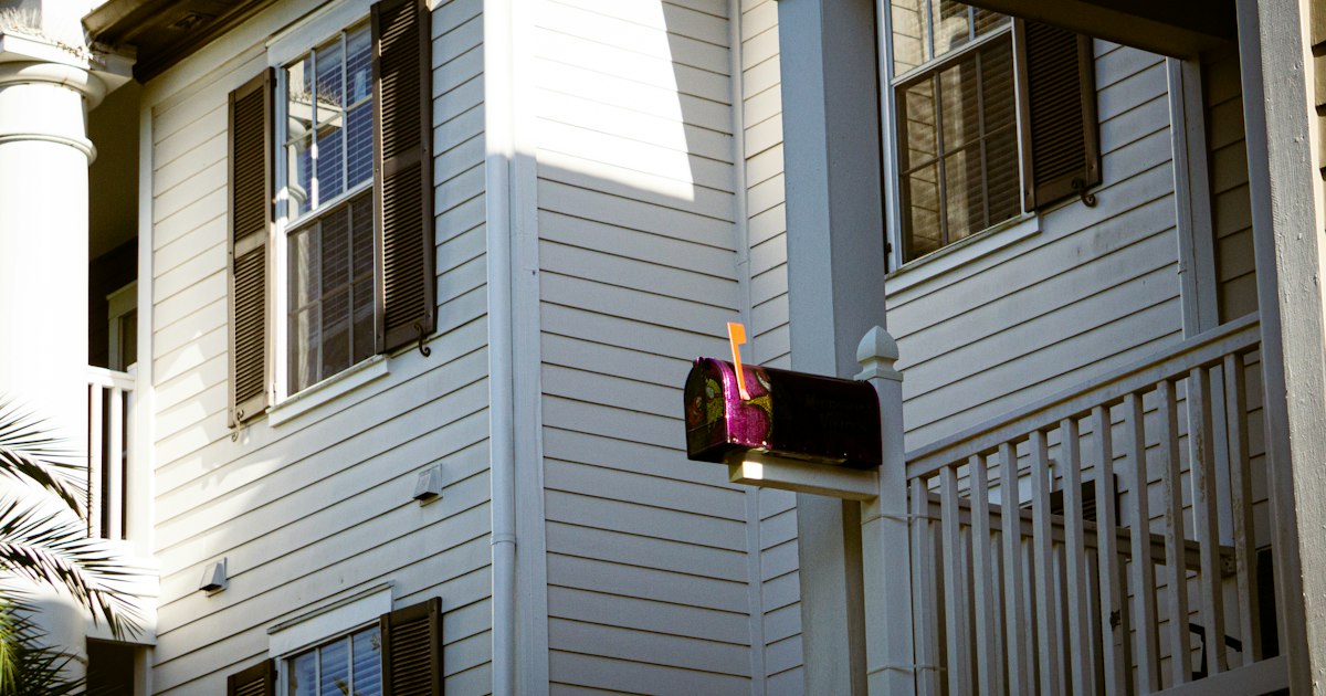 Mailbox with mail on the porch of a white house