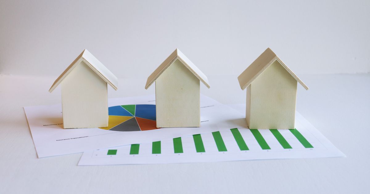 Three wooden model houses on printed charts